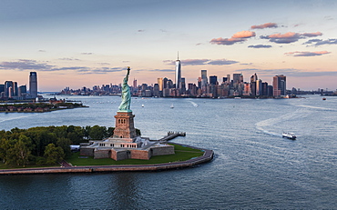 Aerial view of city with Statue of Liberty at sunset, New York City, New York