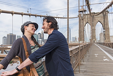 Happy couple flirting on Brooklyn Bridge, Brooklyn, New York