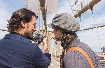 Happy couple photographing Brooklyn Bridge with digital camera, Brooklyn, New York