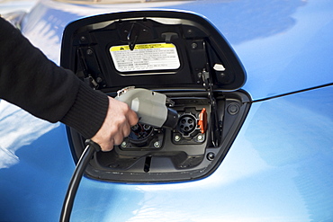 Close-up of man charging electric car