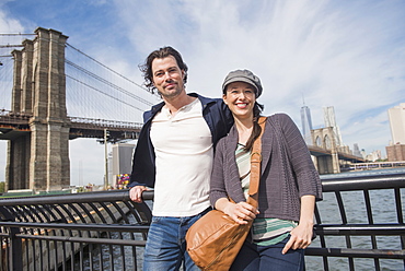 Couple leaning against railing and looking at camera, Brooklyn, New York