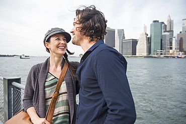 Happy couple standing against city skyline, Brooklyn, New York