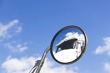 Reflection of semi-truck in side view mirror