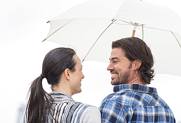 Rear view of couple under umbrella