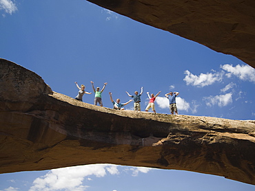 People cheering on rock formation