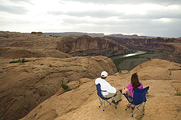 Couple in camping chairs over-looking canyon