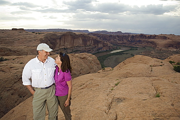 Couple smiling at each other on rock formation