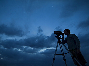 Man using telescope on tripod