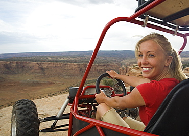 Woman in off-road vehicle at edge of cliff