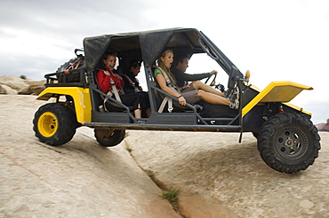 People in off-road vehicle on rock formation