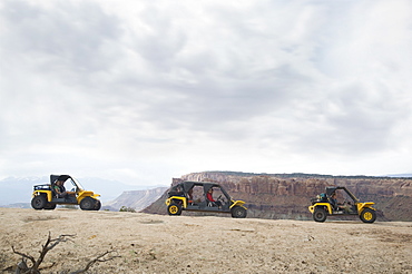 People in off-road vehicles on rock formation