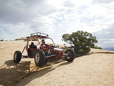 Man in off-road vehicle on rock formation