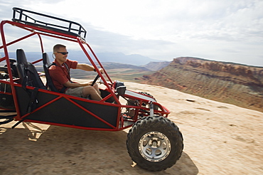 Man in off-road vehicle on rock formation