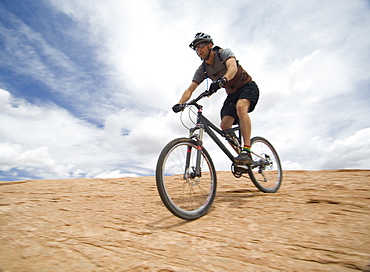 Man riding mountain bike on rock formation