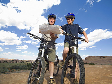 Father and son on mountain bikes with map