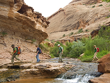 People hiking over stream