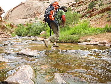 Man hiking through stream