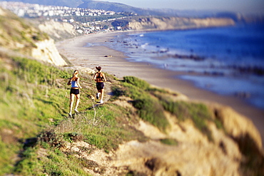 Women jogging on cliff along water