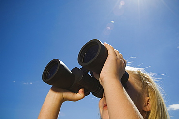 Girl looking through binoculars, Utah, United States