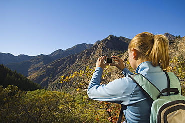 Woman taking photograph of valley, Utah, United States