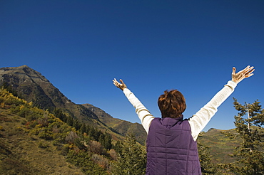 Rear view of woman with arms raised, Utah, United States