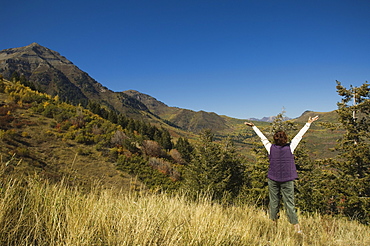 Rear view of woman with arms raised, Utah, United States