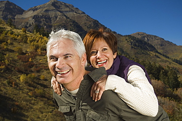 Senior man giving wife piggy back ride, Utah, United States