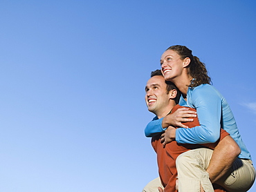 Man giving girlfriend piggy back ride, Utah, United States