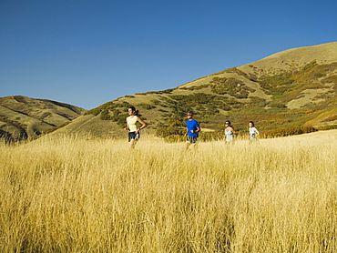 Group of people running in field, Utah, United States