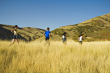 Group of people running in field, Utah, United States