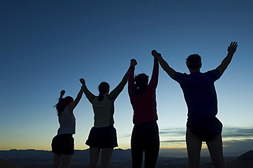 Silhouette of people with arms raised, Salt Flats, Utah, United States