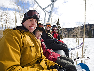 Family sitting on ski lift chair