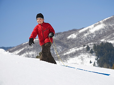 Boy pulling sled in snow