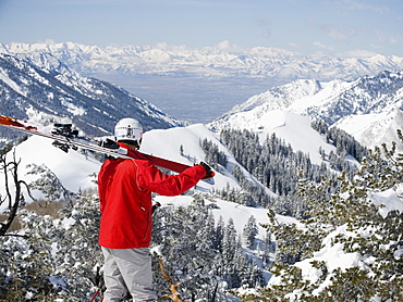 Man holding skis on shoulder