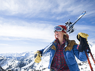 Woman holding skis on shoulder