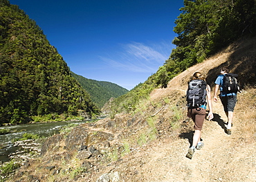 Hikers walking on riverside trail