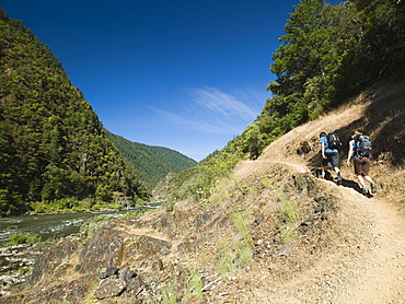 Hikers walking on riverside trail