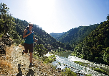 Woman running on riverside trail