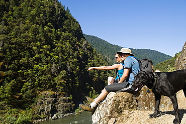 Hikers relaxing on river overlook