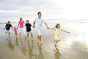 Family holding hands in ocean