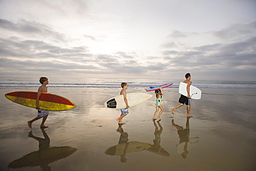 Family carrying surfboards