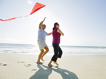 Couple flying kite on beach