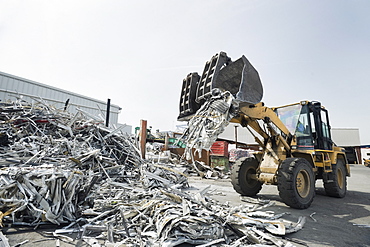 Backhoe dumping recyclable metal