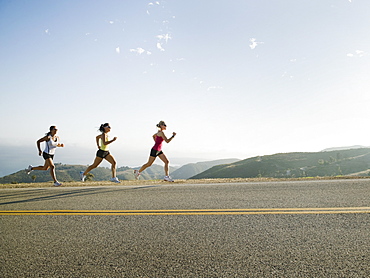 Runners training on side of a road