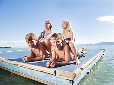 Kids (6-7,8-9,10-11,12-13) playing on raft on lake