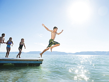 Kids (6-7,8-9,10-11,12-13) playing on raft on lake