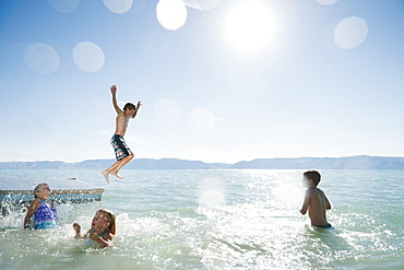 Kids (6-7,8-9,10-11,12-13) playing on raft on lake