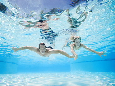 Mid adult couple swimming underwater