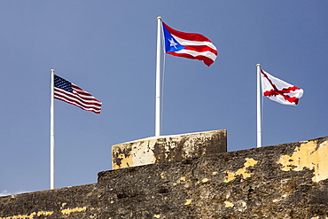 Morro Castle, American, Puerto Rican and naval flags flying against blue sky, El Morro, San Juan, Puerto Rico