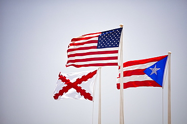 Morro Castle, American, Puerto Rican and naval flags flying against blue sky, El Morro, San Juan, Puerto Rico